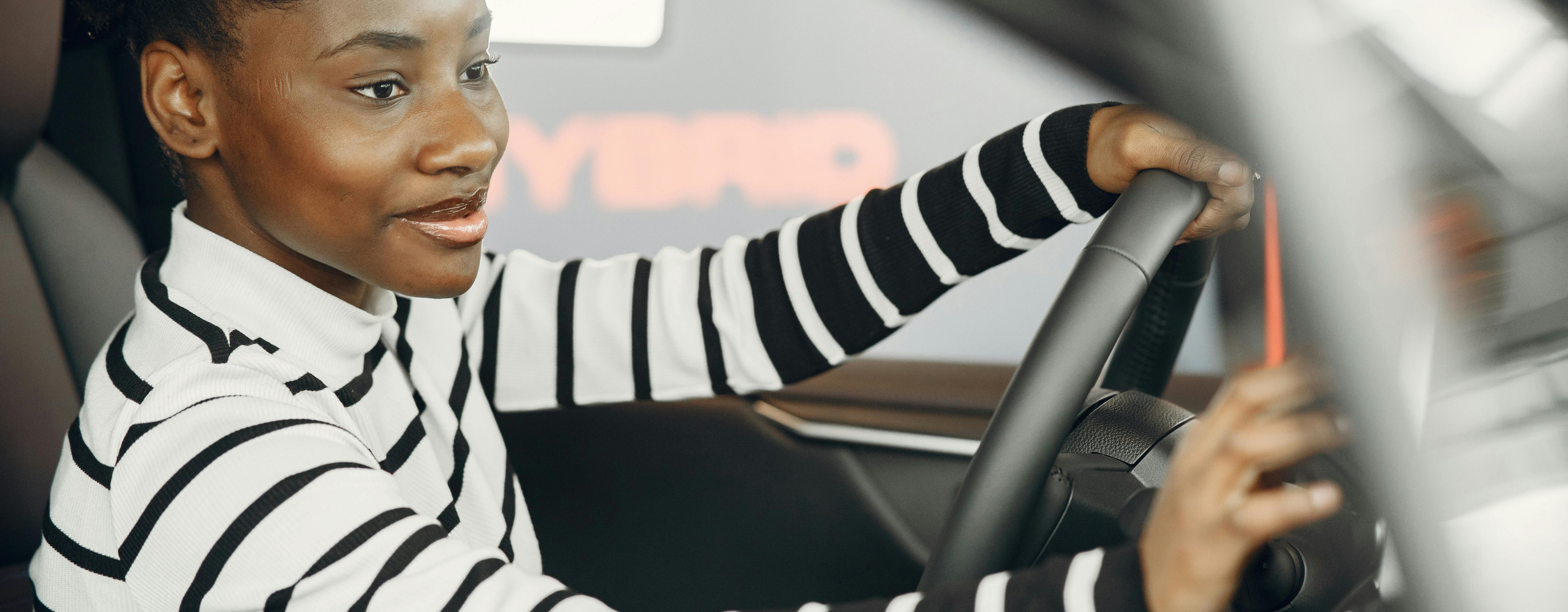 woman of color smiling behind the steering wheel